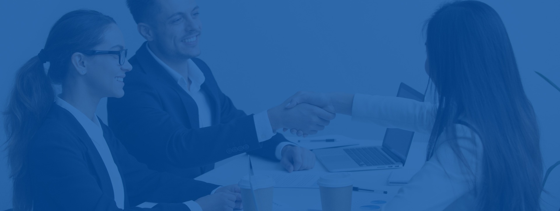 Friendly partners handshaking at group meeting thanking for succ